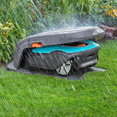 Robotmaaier onder een beschermhuis in de tuin